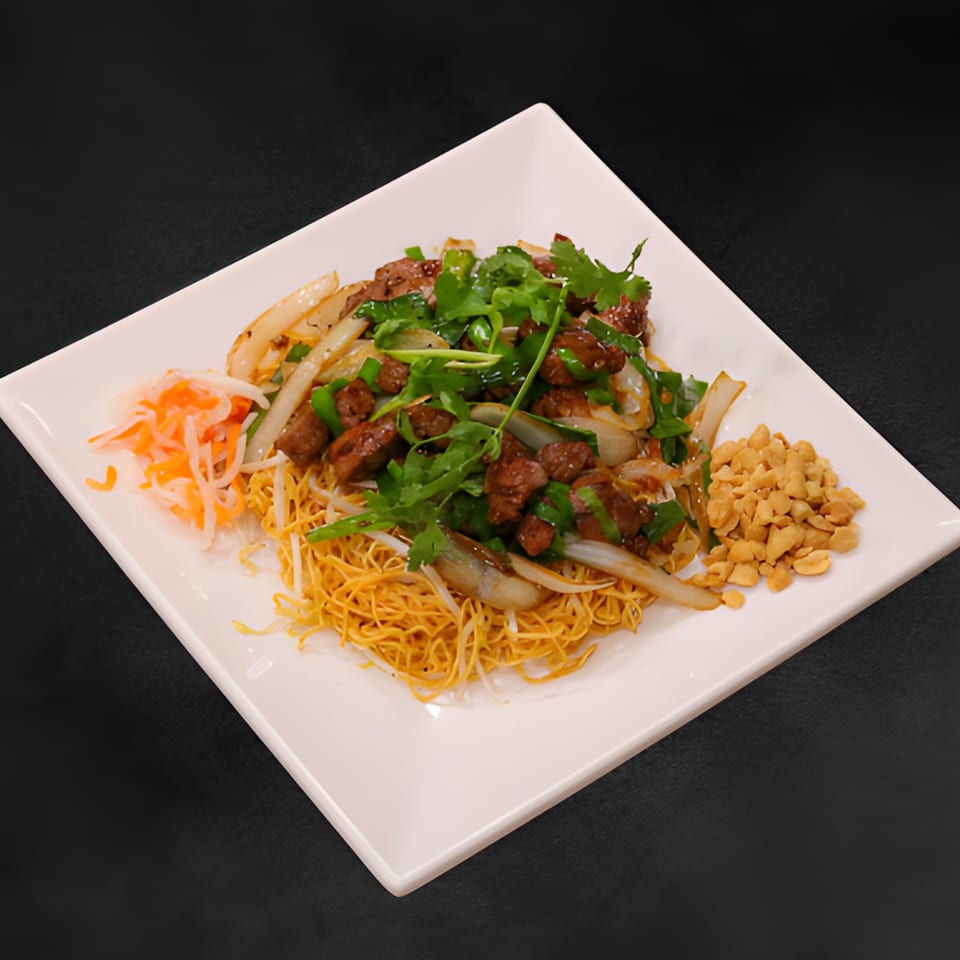 Vietnamese crispy noodles topped with beef, onions, cilantro, pickled carrots, and peanuts.